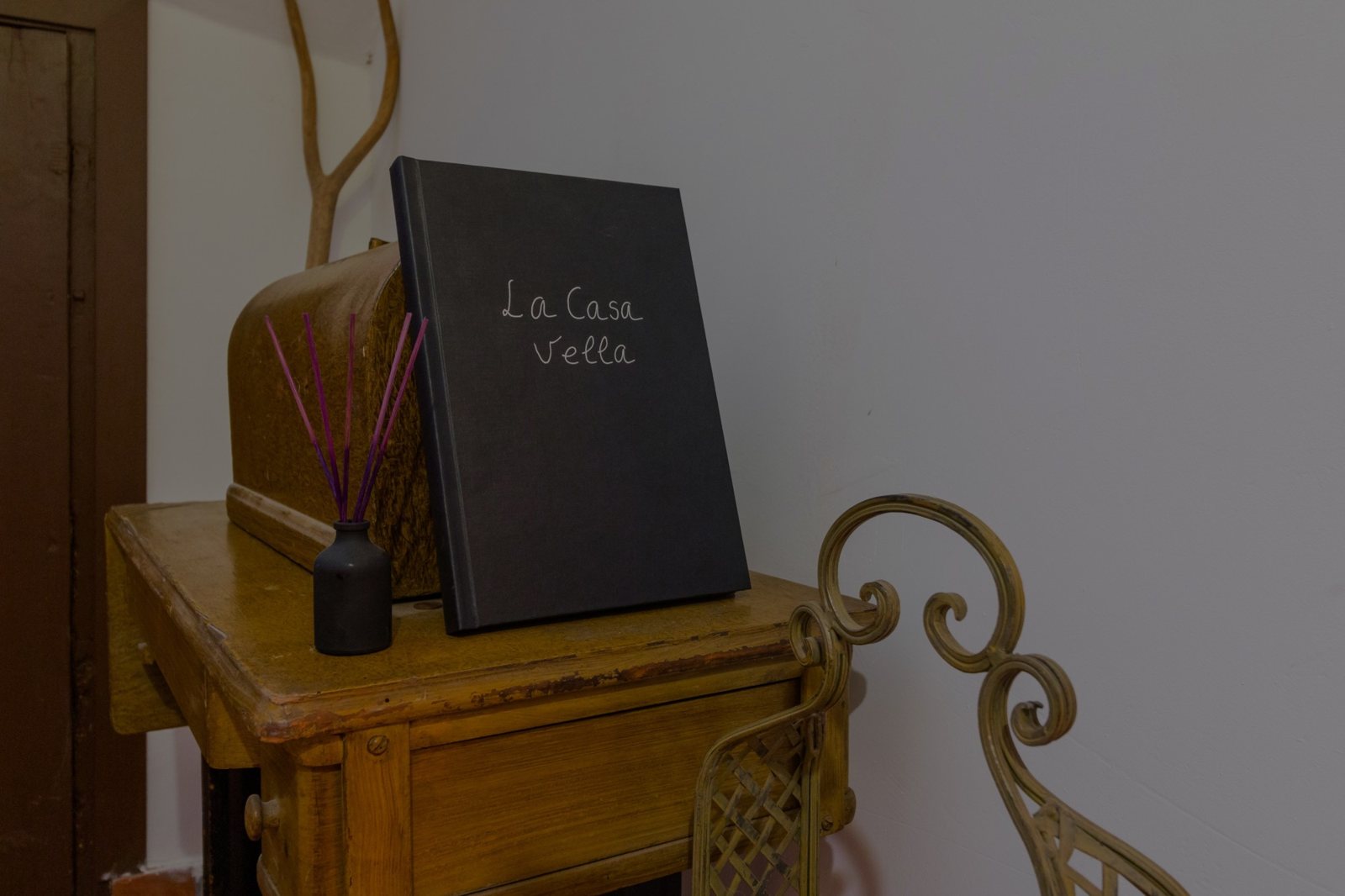 Llibre de La Casa Vella sobre una màquina de cosir antiga